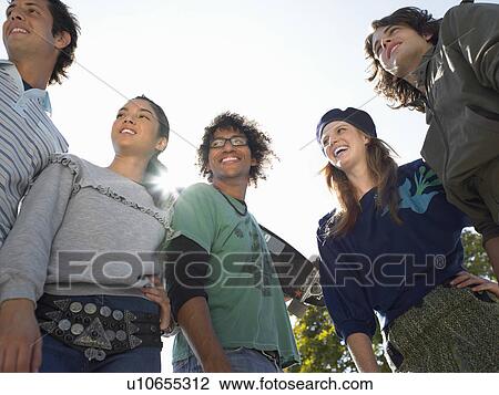 Stock Image - Trendy friends, outdoors, low angle view. Fotosearch