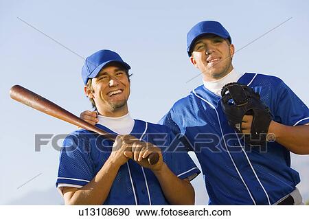 Two baseball team-mates holding baseball bats, (low angle view) View Large Photo Image Stock Image - Two baseball team-mates holding baseball bats, (low angle view). Fotosearch