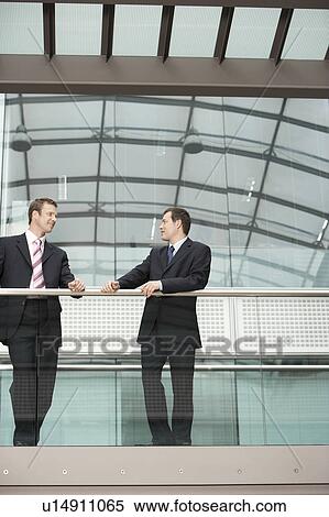 Two Businessmen Talking in office View Large Photo Image Stock Photography - Two Businessmen Talking in office. Fotosearch