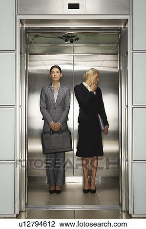 Two Businesswomen in Office Elevator View Large Photo Image Stock Image - Two Businesswomen in Office Elevator. Fotosearch