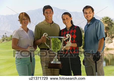 Stock Photo - Two couples of golfers holding trophy, (portrait). Fotosearch