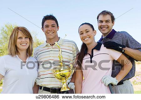 Two couples of golfers holding trophy, (portrait) View Large Photo Image Stock Photograph - Two couples of golfers holding trophy, (portrait). Fotosearch