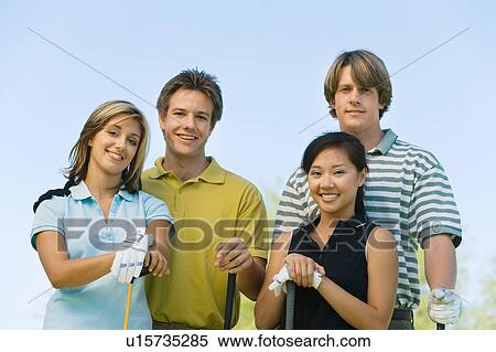 Two couples of golfers posing on golf course, (portrait) View Large Photo Image Stock Photography - Two couples of golfers posing on golf course, (portrait). Fotosearch