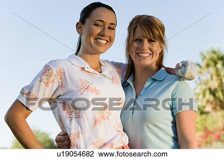 Two female golfers embracing, (portrait) View Large Photo Image Stock Image - Two female golfers embracing, (portrait). Fotosearch