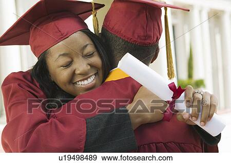 Stock Photo - Two graduates hugging outside. Fotosearch
