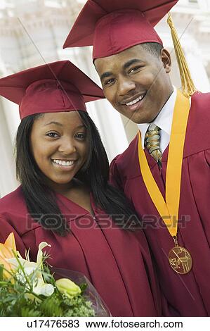 Stock Image - Two graduates outside, portrait. Fotosearch