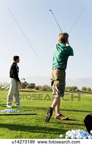Stock Photo - Two man practising at golf course. Fotosearch