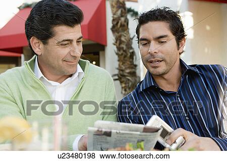Stock Photo - Two men reading newspaper, portrait. Fotosearch