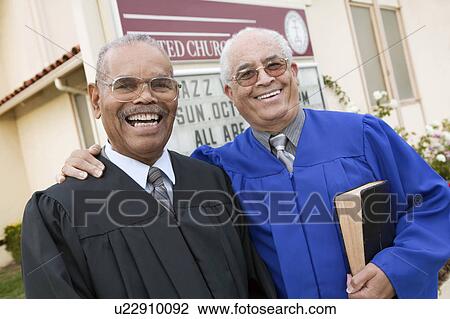 Stock Image - Two Ministers in Front of Church, portrait. Fotosearch