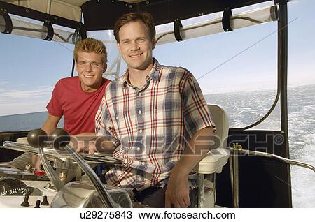 Stock Image - Two people in boat cabin, (portrait). Fotosearch
