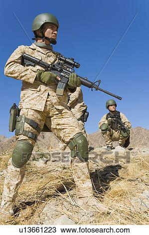 Stock Image - Two soldiers on patrol in field. Fotosearch