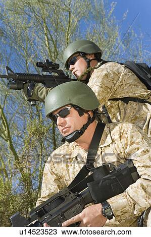 Stock Image - Two soldiers on patrol, outdoors. Fotosearch