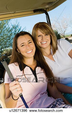 Two women golfers sitting in golf cart, (portrait) View Large Photo Image Stock Photograph - Two women golfers sitting in golf cart, (portrait). Fotosearch