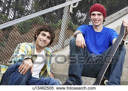 Stock Photography - Two young skateboarders sitting on stairs. Fotosearch