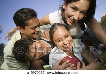 Stock Photo - Two young women and two young men playing football outdoors.. Fotosearch