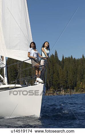 Two young women standing on bow of sailboat View Large Photo Image Picture - Two young women standing on bow of sailboat. Fotosearch