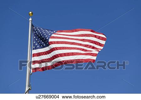 Picture - United States flag flapping against clear sky, (low angle view). Fotosearch