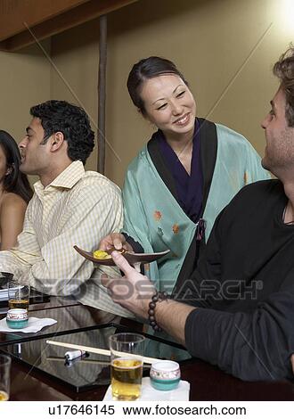 Stock Photography - Waitress serving sushi to restaurant. Fotosearch