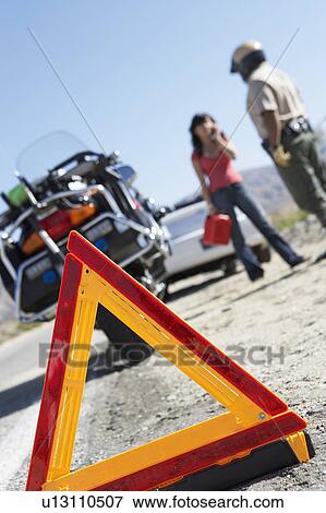 Warning triangle behind police motorcycle and stopped car View Large Photo Image Stock Photo - Warning triangle behind police motorcycle and stopped car. Fotosearch