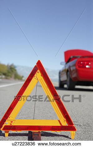 Warning triangle in front of broken down red sports car at side of road View Large Photo Image Stock Photograph - Warning triangle in front of broken down red sports car at side of road. Fotosearch