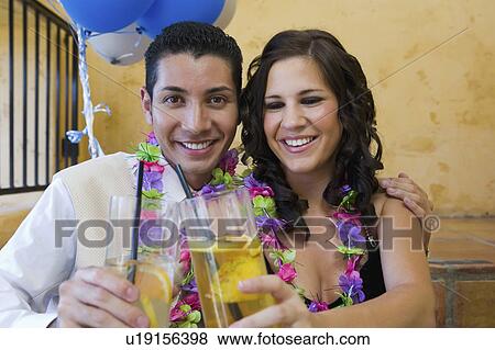 Well-dressed teenage couple toasting drinks outside school dance View Large Photo Image Stock Photo - Well-dressed teenage couple toasting drinks outside school dance. Fotosearch