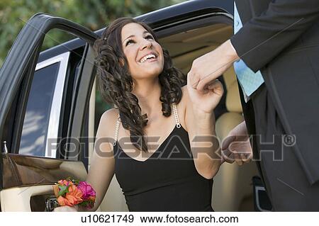 Well-dressed teenager girl being helped out of limo by date View Large Photo Image Stock Photo - Well-dressed teenager girl being helped out of limo by date. Fotosearch