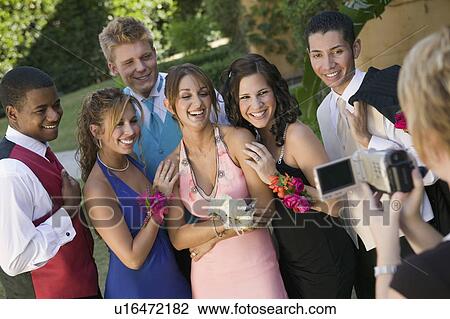 Well-dressed teenagers posing for video camera outside school dance View Large Photo Image Stock Image - Well-dressed teenagers posing for video camera outside school dance. Fotosearch