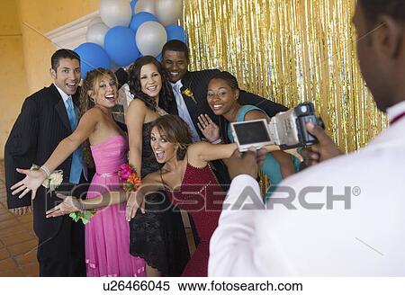 Well-dressed teenagers posing for video camera at school dance View Large Photo Image Stock Photography - Well-dressed teenagers posing for video camera at school dance. Fotosearch