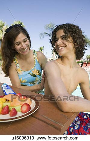 Woman applying sunscreen to son (13-15) at swimming pool. View Large Photo Image Stock Image - Woman applying sunscreen to son (13-15) at swimming pool.. Fotosearch