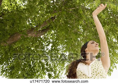 Stock Image - Woman dancing, low angle view.. Fotosearch
