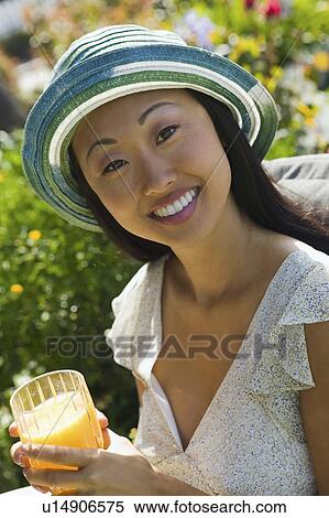 Woman drinking orange juice, outdoors, (portrait) View Large Photo Image Stock Photography - Woman drinking orange juice, outdoors, (portrait). Fotosearch