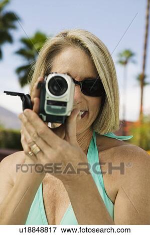 Stock Photo - Woman holding camcorder, front view.. Fotosearch