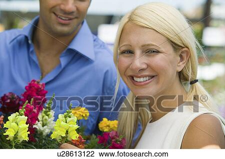Stock Image - Woman Holding Flowers, portrait. Fotosearch
