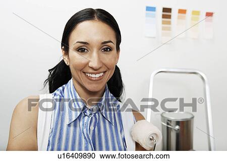 Woman holding small paint roller, portrait View Large Photo Image Stock Image - Woman holding small paint roller, portrait. Fotosearch