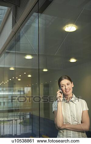 Stock Image - Woman in Office on Cell Phone. Fotosearch
