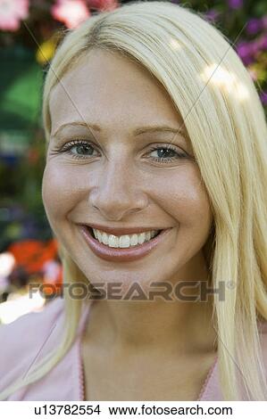 Picture - Woman in plant nursery, portrait, close up. Fotosearch
