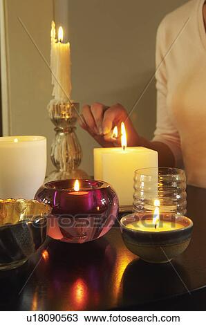 Woman Lighting Candles on table, mid section, close-up View Large Photo Image Stock Image - Woman Lighting Candles on table, mid section, close-up. Fotosearch