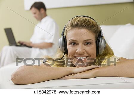 Woman Listening to Music While Husband Works View Large Photo Image Stock Photo - Woman Listening to Music While Husband Works. Fotosearch