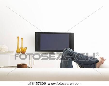 Woman lying on sofa, low section View Large Photo Image Stock Photo - Woman lying on sofa, low section. Fotosearch