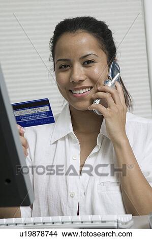 Woman making credit card purchase on cell phone, portrait View Large Photo Image Picture - Woman making credit card purchase on cell phone, portrait. Fotosearch
