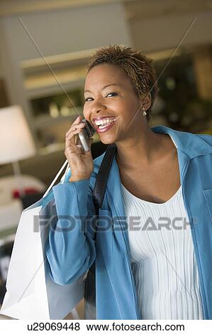 Stock Photo - Woman on Cell Phone in furniture store, portrait. Fotosearch