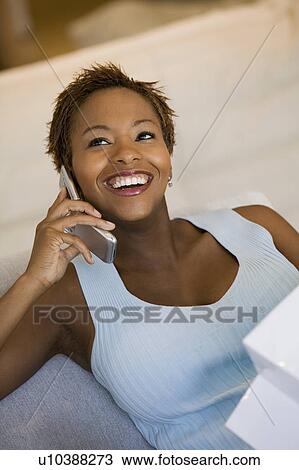 Woman on sofa talking on cell phone View Large Photo Image Stock Image - Woman on sofa talking on cell phone. Fotosearch