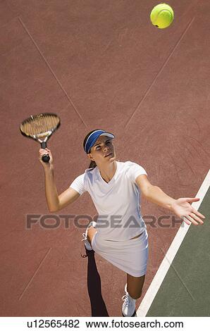 Woman on tennis court Serving Tennis Ball, elevated view View Large Photo Image Stock Image - Woman on tennis court Serving Tennis Ball, elevated view. Fotosearch