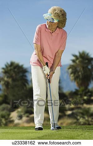 Stock Image - Woman playing golf. Fotosearch