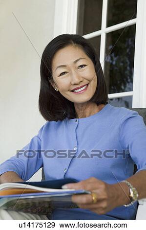 Woman relaxing on armchair outdoors, (portrait) View Large Photo Image Stock Photo - Woman relaxing on armchair outdoors, (portrait). Fotosearch