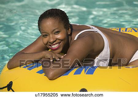 Woman Relaxing on inflatable raft in swimming pool, portrait. View Large Photo Image Stock Photography - Woman Relaxing on inflatable raft in swimming pool, portrait.. Fotosearch