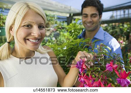 Stock Image - Woman selecting Flowers in plant nursery, portrait. Fotosearch