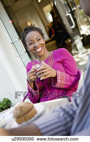 Stock Image - Woman sitting at cafe table, portrait. Fotosearch