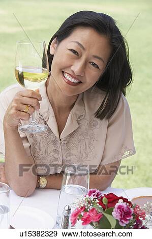 Woman sitting holding wine glass View Large Photo Image Stock Photo - Woman sitting holding wine glass. Fotosearch