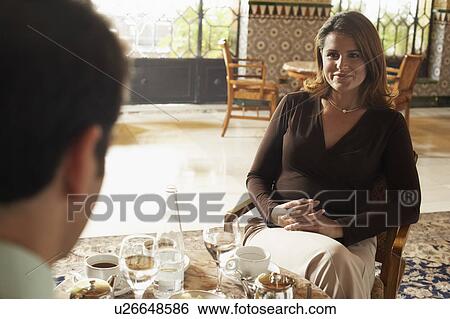 Woman sitting in restaurant with man, just seen. View Large Photo Image Stock Photograph - Woman sitting in restaurant with man, just seen.. Fotosearch